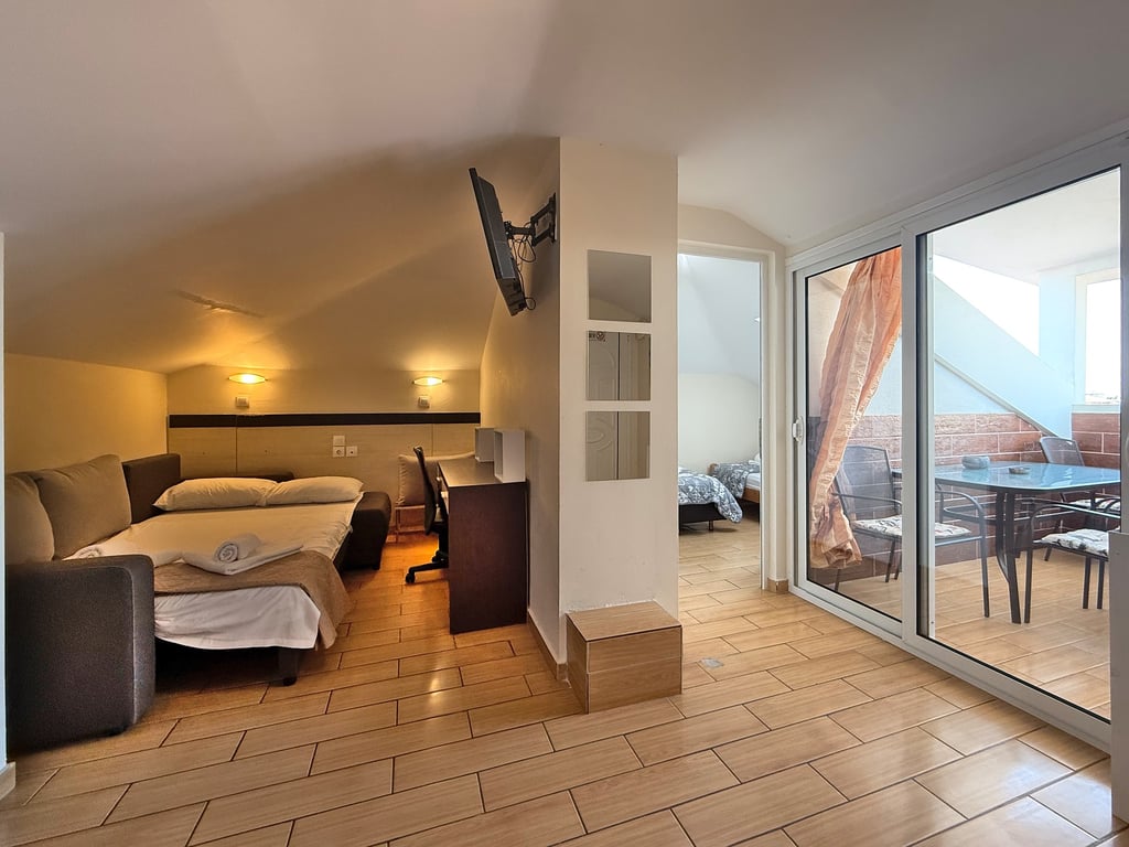 Dnevni deo apartmana sa ležajem na razvlačenje i izlazom na terasu